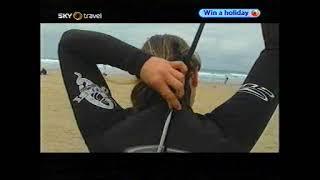 Surfer girl puts on wetsuit