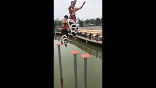 Dancers practice traditional Chinese lion dance on poles in water