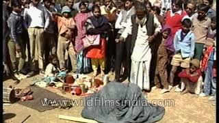 Indian street magician makes a young boy disappear into a jute basket