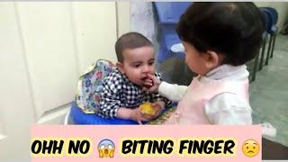 baby biting his sisters finger 