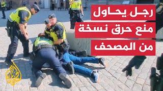 شاهد  الشرطة السويدية تعتقل رجلا حاول منع حرق نسخة من المصحف الشريف