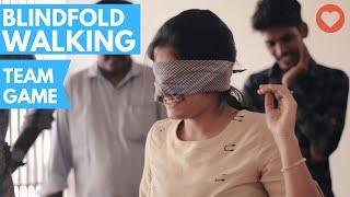 Employees playing blindfold game to build team spirit