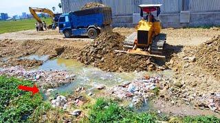 Perfectly skill bulldozer Build foundation road move dirt to fill stone with dump trucks unload