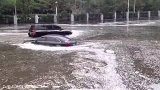 Hot Japanese Girl Driving Car Through Flooded Street