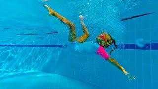 Funny Girl swims in the swimming pool with water slides and inflatable trampolines