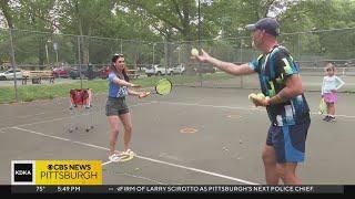 Mary Ours gets tennis lessons on 143 Day