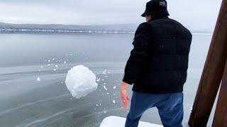 throwing a big snowball into an icy lake