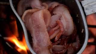 Cooking bacon on a canteen cup.