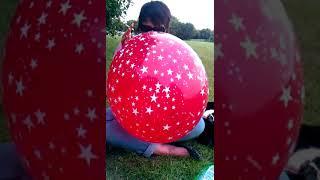 Nice Girl Blow to Pop a Red Stars Balloon Outdoors