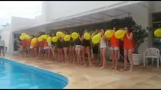 Many Girls Blow to Pop Balloons on a Competition