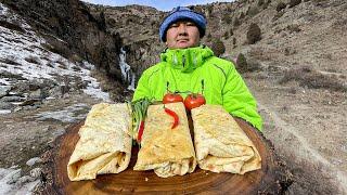 SHAWARMA MADE OF BEEF COOKED IN AN AFGHAN CAULDRON IN NATURE  4K VIDEO WITH THE SOUND OF WATERFALL