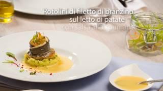 Rotolini di filetto di branzino su un letto di patate con salsa allo spumante