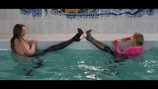 A WETLOOK of GIRLS in leggings boots and heels in the pool 