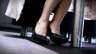 Candid high heel ladys feet under a table in a restaurant 4k quality in cinematic vertical format