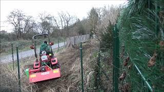 Rodung einer wildbewachsenen Gartenfläche mittels Schlegelmulcher am Traktor.