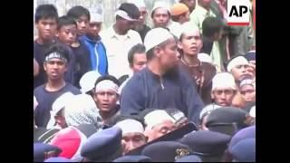 Supporters and police push and shove as coffins are carried through Lamongan