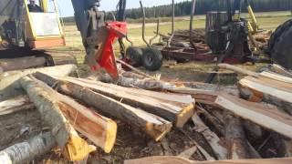 Puun halontaa kaivinkoneellaexcavator splitting wood