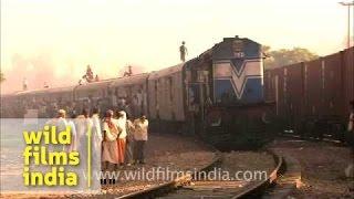 Packed Indian train with school-boy running on the roof