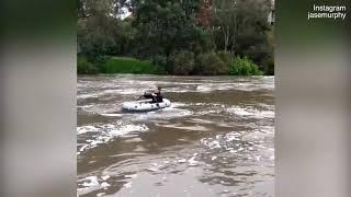 Man floats down an overflowing Yarra river in Melbourne