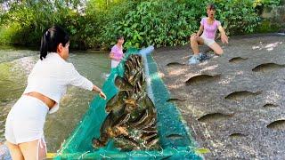 The girl makes a large fish trap and harvests it full of fish traps