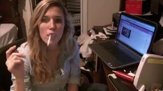 Girl smokes by a laptop