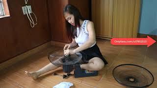 Beautiful single mom cleaning wall fan on weekends