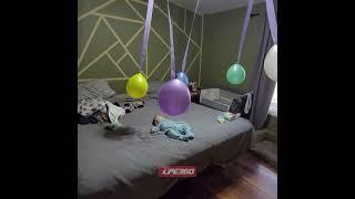 Balloons rotate from fan over baby on bed