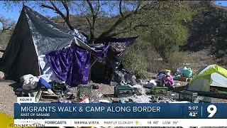 Migrants walk and wait for Border Patrol at camp near Sasabe