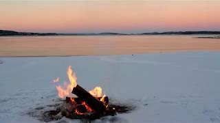 Campfire at a snowy beach at sunset - a relaxing nature video