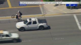 Police chase bystander on bicycle wheelies into frame