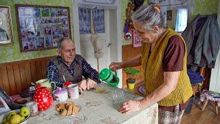 Happy old age of an elderly couple in a mountain village in winter far from civilization