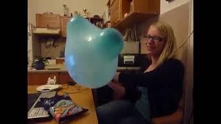 Blonde Girl Blows to Pop a Blue Mouse Ears Balloon