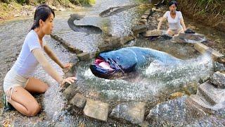 Girl uses stream rocks to create a large circular fish trap to harvest many large catfish