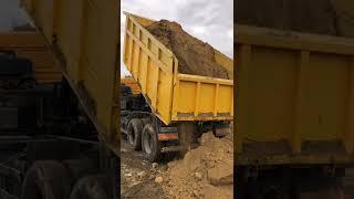 Kamaz 6540 Russian dump truck unloads clay in the mud