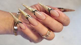 Sculpting stiletto shape nails with buldier gel on forms. Glitter encapsulation with french.