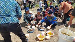 Bacons Journey Yi people in Daliangshan sit on the ground having pots of beef.
