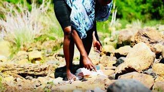 African Village Girl Slaughtering Chicken Barefoot At The River