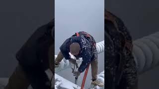 This Chinese worker is working to fix the power in the middle of a storm