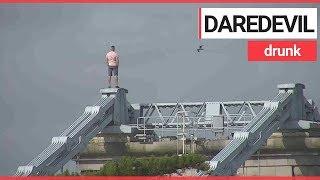 Drunk man scales 150ft bridge to escape police  SWNS TV