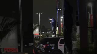 Man Stands on LA cop car