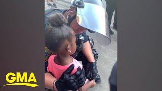 Police officer comforts little girl after she asks Are you going to shoot us? l GMA Digital