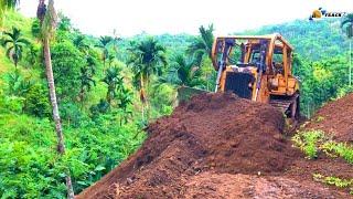 Extreme The D6R XL Bulldozer forms a new road by cutting a hillside at the edge of a ravine