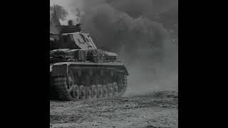 Panzer III and IV rolling past a burning Soviet BA-10 armored car on the Eastern Front in 1941