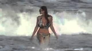 Busty bikini-clad girl comes in from the surf