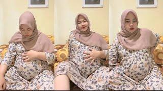 Bunda hamil jilbab cantik duduk santai di kasur