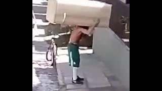 Man Carry a Fridge On His Shoulder While Riding a Bike