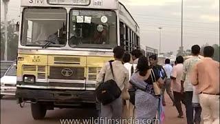 Delhi DTC diesel bus service circa 1998 - commuters board moving Blueline and Redline buses