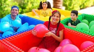 Jason y Alex juegan al Desafío de globos de agua de cuatro colores para niños