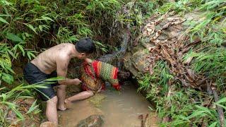 Primitive life The forest people are curious to see the girl catching a big fish under the cliff