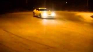 Toyota supra drifting around a roundabout infront of  cops